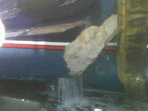 Water pours out of the cracked hull